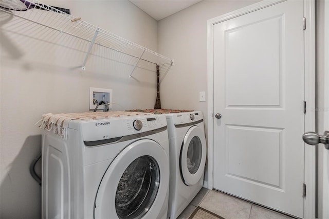 laundry area with light tile patterned flooring and washing machine and dryer