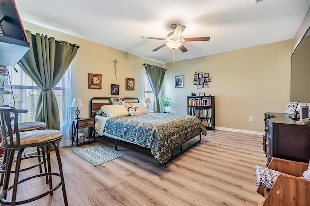 bedroom featuring multiple windows, ceiling fan, and light hardwood / wood-style floors