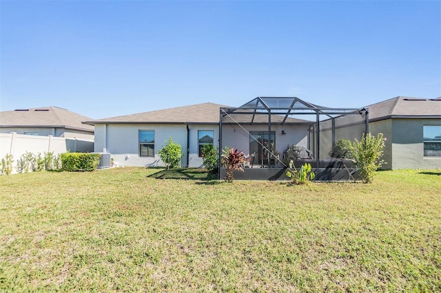 rear view of property featuring a lanai, a yard, and central AC unit