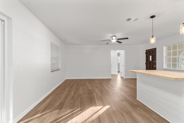 unfurnished living room with ceiling fan and hardwood / wood-style floors