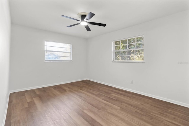 empty room with hardwood / wood-style flooring, plenty of natural light, and ceiling fan