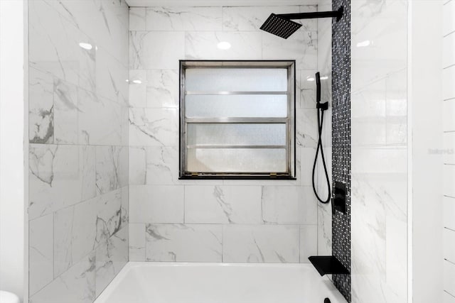 bathroom featuring tiled shower / bath and a wealth of natural light