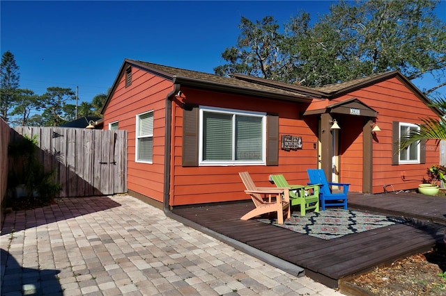 back of house featuring a deck and a patio