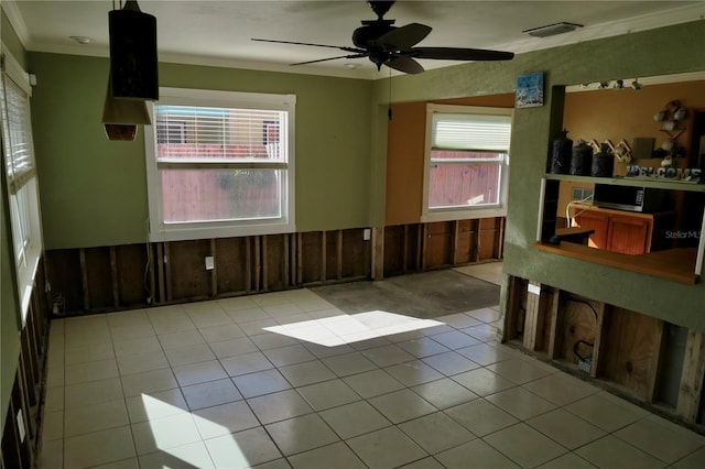 tiled spare room with ceiling fan and ornamental molding