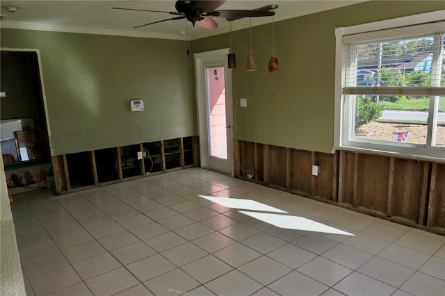 tiled spare room with crown molding, wooden walls, and ceiling fan