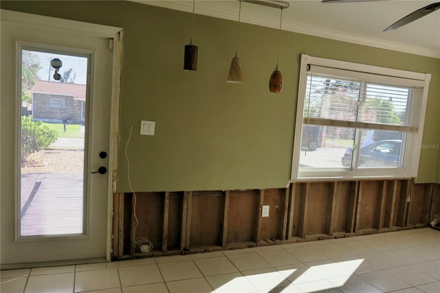 interior space featuring ceiling fan, a healthy amount of sunlight, light tile patterned flooring, and ornamental molding