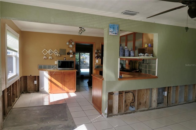 kitchen with light tile patterned floors, plenty of natural light, and ornamental molding