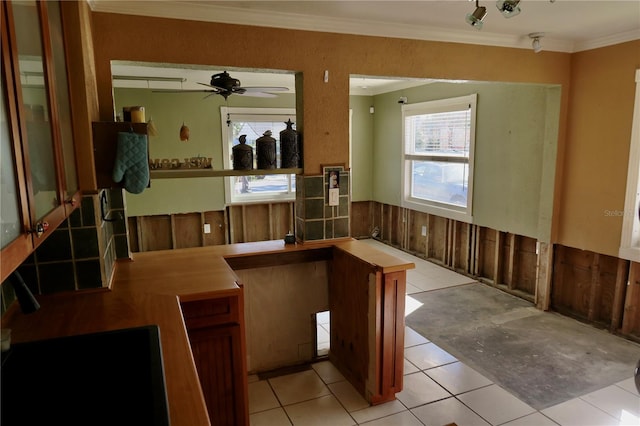 kitchen with light tile patterned floors, ceiling fan, and ornamental molding