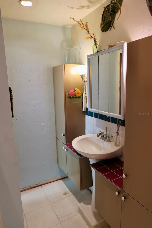 bathroom featuring tile patterned floors, sink, and tasteful backsplash