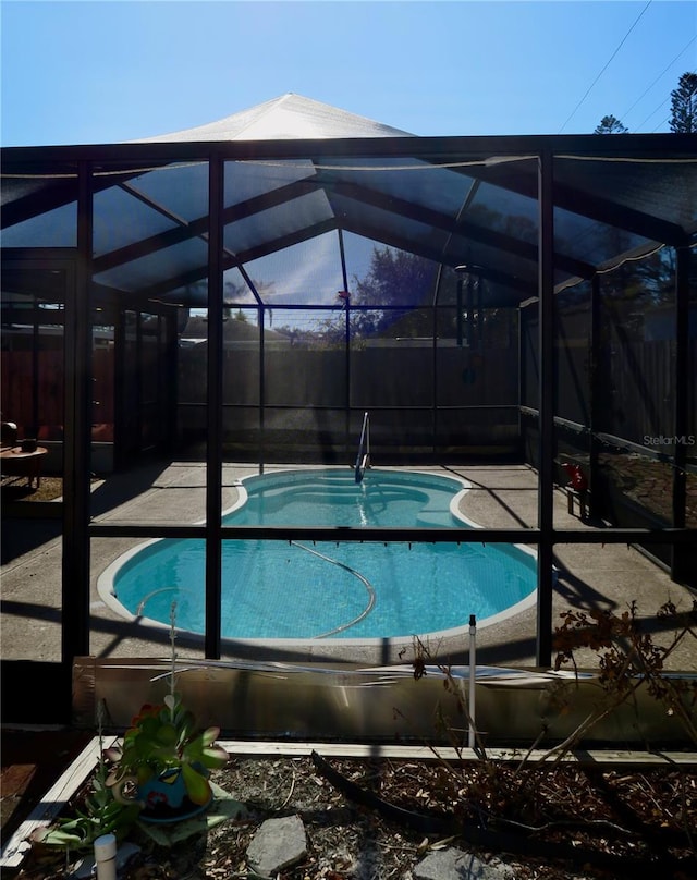 view of pool with a patio area and a lanai