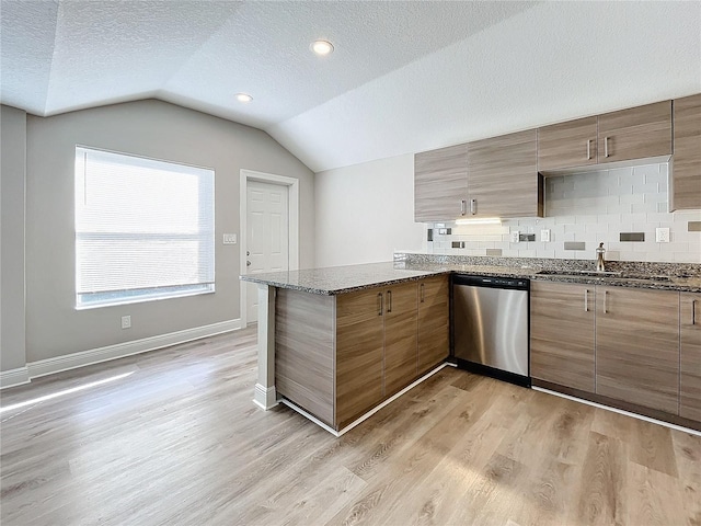 kitchen with sink, stainless steel dishwasher, kitchen peninsula, light hardwood / wood-style floors, and lofted ceiling