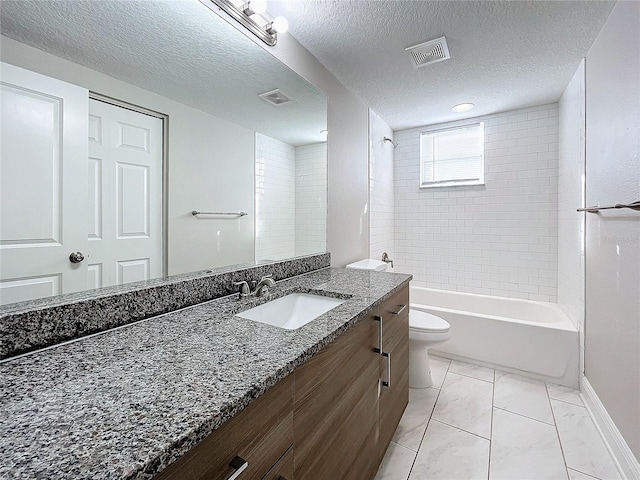 full bathroom with tiled shower / bath combo, toilet, a textured ceiling, and vanity