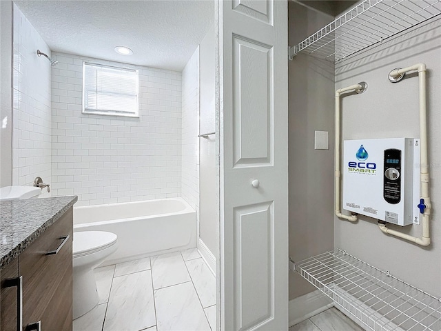 full bathroom with vanity, tankless water heater, tiled shower / bath, toilet, and a textured ceiling