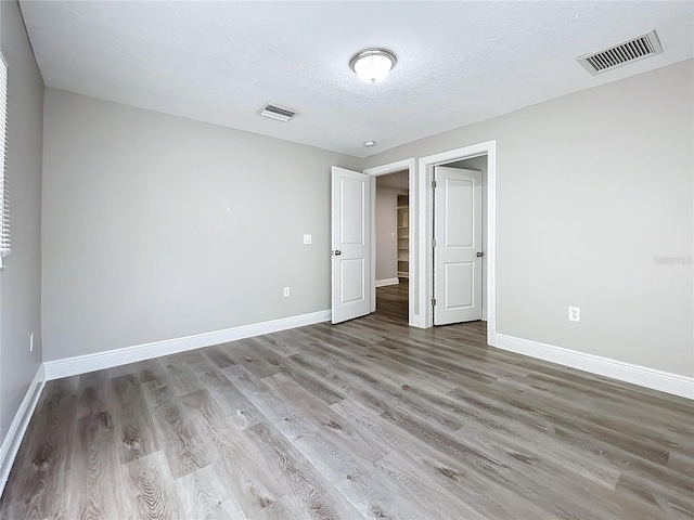 unfurnished bedroom featuring hardwood / wood-style floors and a textured ceiling