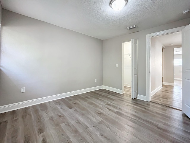 empty room featuring a textured ceiling and hardwood / wood-style flooring