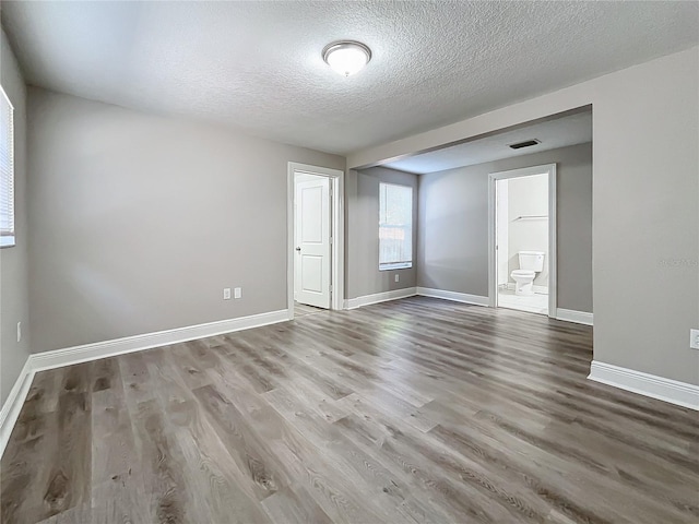 spare room with wood-type flooring and a textured ceiling