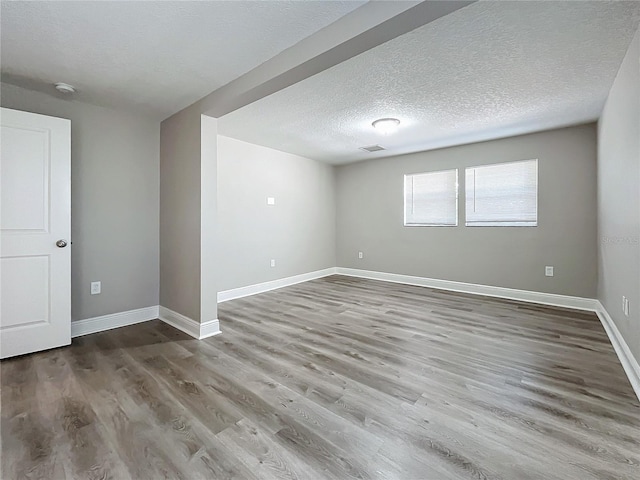 empty room featuring hardwood / wood-style flooring and a textured ceiling