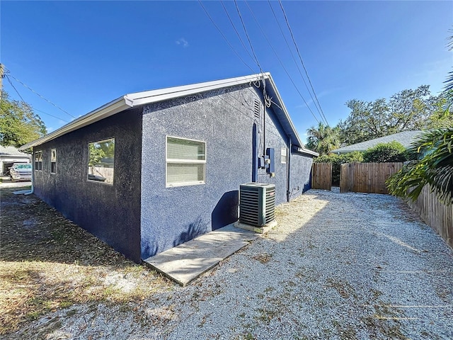 view of side of home with central AC unit