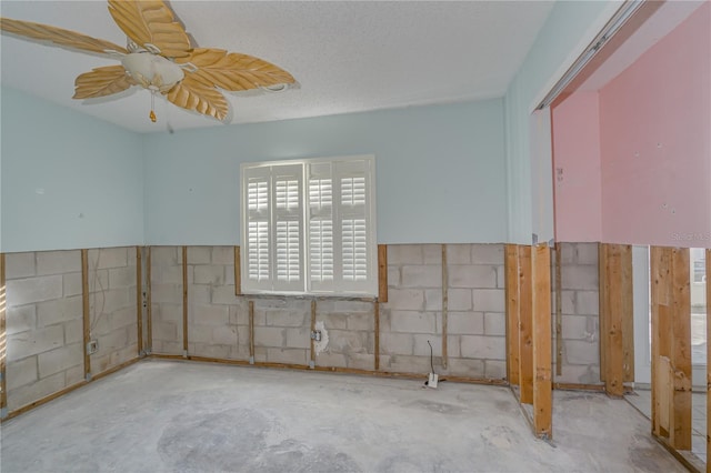 unfurnished room featuring ceiling fan, concrete flooring, and a textured ceiling