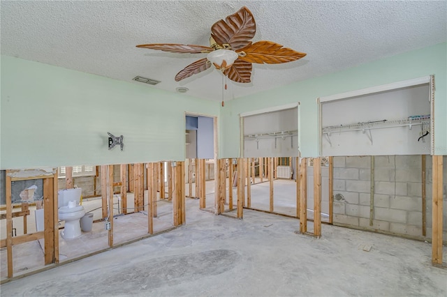 misc room with concrete flooring, a textured ceiling, and ceiling fan