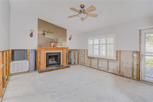 unfurnished living room with ceiling fan, concrete flooring, and lofted ceiling