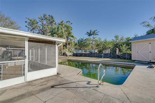 view of pool featuring a patio area, a sunroom, and a storage unit