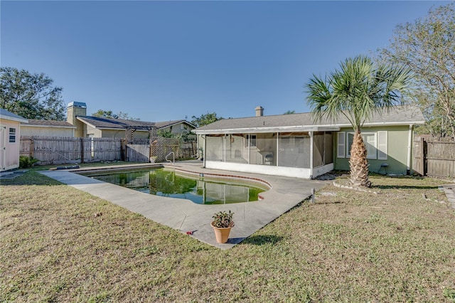 view of swimming pool featuring a sunroom and a yard