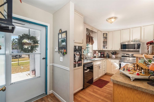 kitchen featuring white cabinetry, sink, light wood-type flooring, and stainless steel appliances