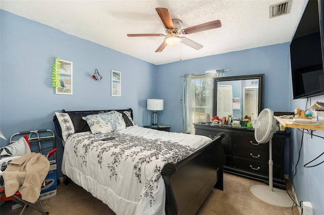 carpeted bedroom with a textured ceiling and ceiling fan