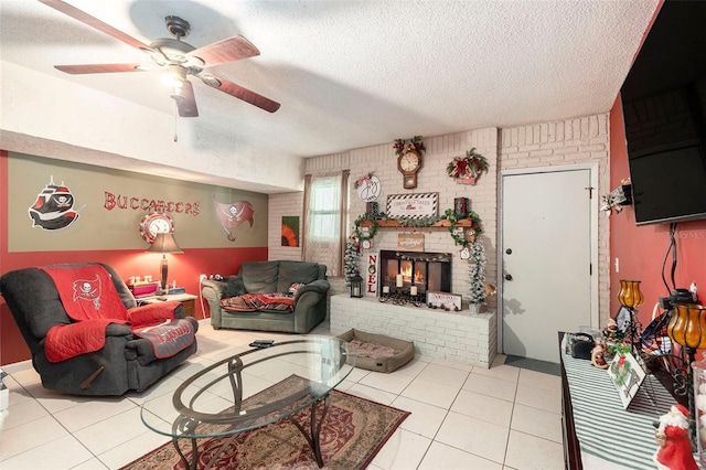 living room featuring ceiling fan, light tile patterned floors, brick wall, and a textured ceiling