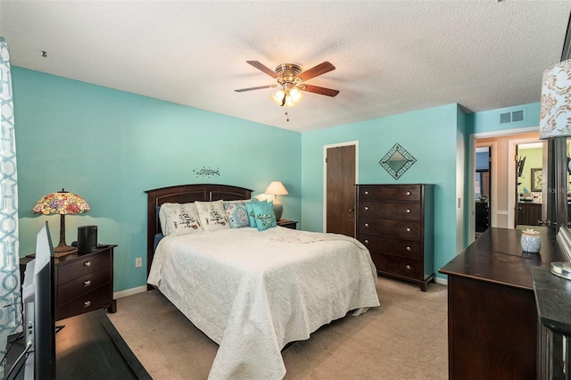 carpeted bedroom featuring a textured ceiling and ceiling fan