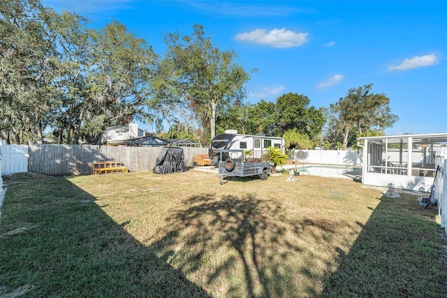 view of yard featuring a fenced in pool and a sunroom