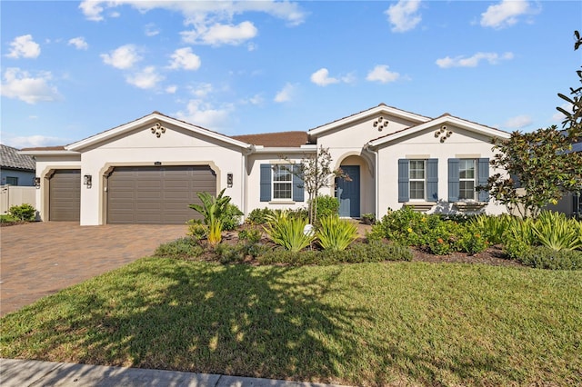 ranch-style house with a garage and a front lawn