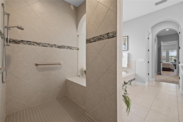 bathroom featuring tile patterned floors and a tile shower