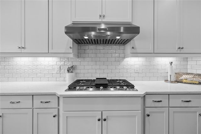 kitchen featuring white cabinetry, stainless steel gas stovetop, and wall chimney range hood