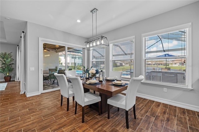 dining space featuring dark wood-type flooring, ceiling fan, and a healthy amount of sunlight