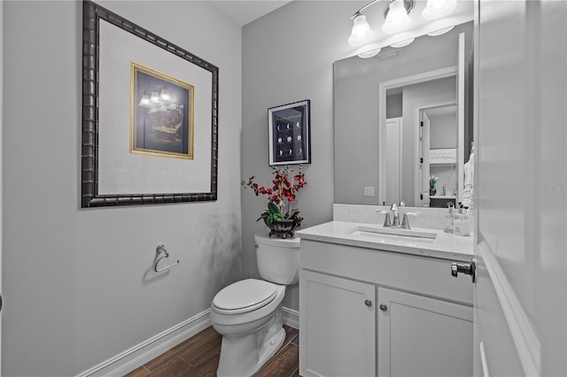 bathroom featuring wood-type flooring, vanity, and toilet