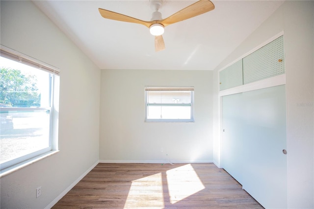 unfurnished bedroom featuring multiple windows, ceiling fan, and light hardwood / wood-style flooring