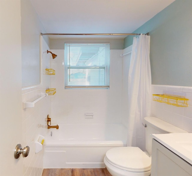 full bathroom featuring vanity, hardwood / wood-style flooring, toilet, tile walls, and shower / tub combo with curtain