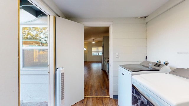 clothes washing area with washer and clothes dryer and dark hardwood / wood-style flooring