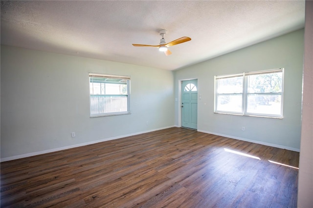 empty room featuring a textured ceiling, dark hardwood / wood-style flooring, ceiling fan, and lofted ceiling