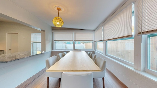 dining area featuring light wood-type flooring, a wealth of natural light, and vaulted ceiling