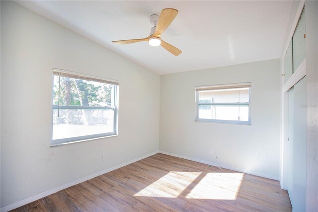 unfurnished room with a wealth of natural light, ceiling fan, lofted ceiling, and light wood-type flooring