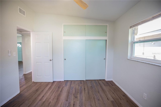 unfurnished bedroom with dark hardwood / wood-style flooring, ceiling fan, a closet, and vaulted ceiling