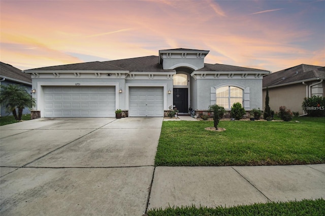 view of front of home with a yard and a garage