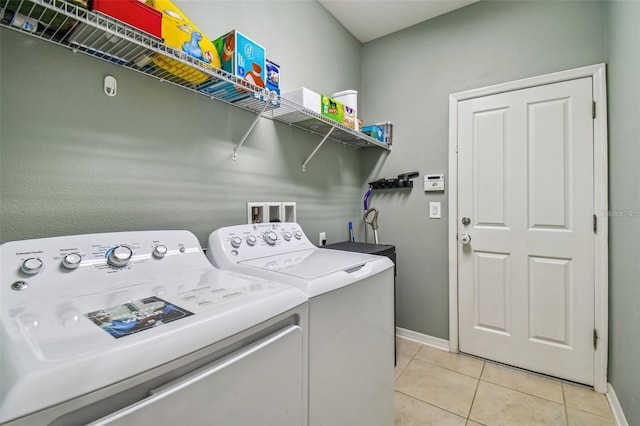 laundry area featuring light tile patterned floors and washer and dryer