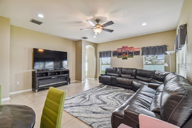 living room with a wealth of natural light, light tile patterned floors, and ceiling fan