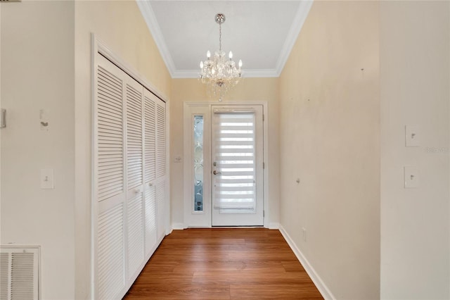 doorway to outside featuring ornamental molding, dark hardwood / wood-style floors, and a notable chandelier