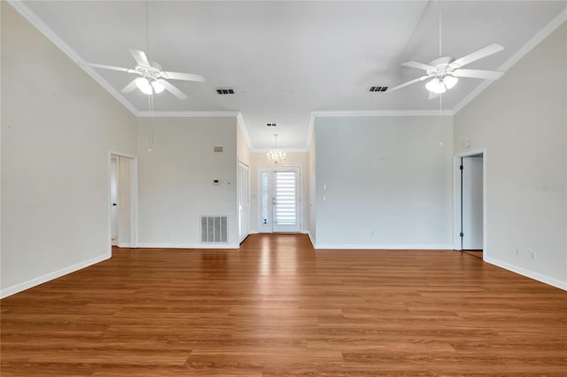 unfurnished living room with ceiling fan with notable chandelier, wood-type flooring, ornamental molding, and a towering ceiling