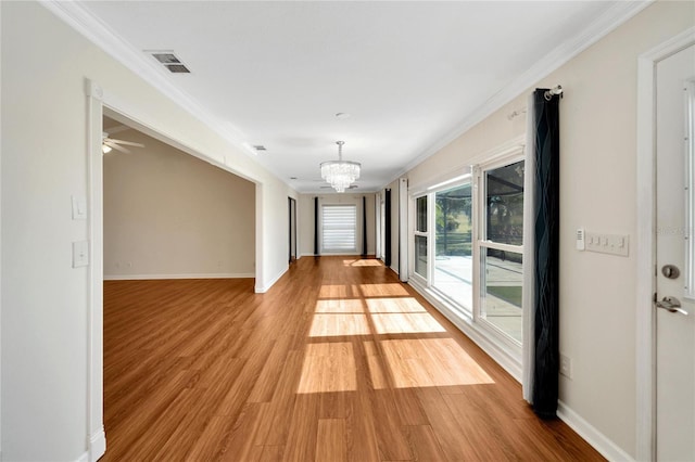 hall featuring a chandelier, crown molding, and light hardwood / wood-style flooring